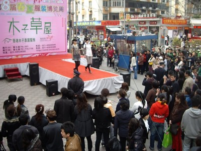 Défilé de mode dans la rue devant le marché aux faux