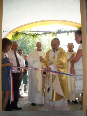 Monseigneur Freidier coupe le ruban tricolore.